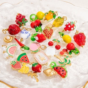 Colorful fruit and mahjong charms in a frosted glass bowl, handmade jewelry accessories