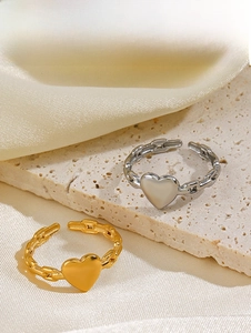 Detail von Gold- und Silber-Herzringen mit Kettentextur und verstellbarem Ringband
