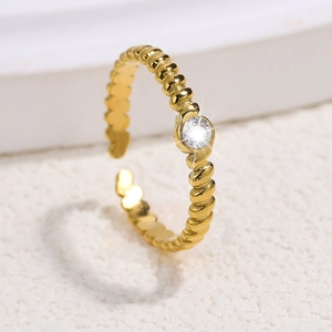 Detailed close-up of golden beaded open ring with a brilliant round cubic zirconia stone