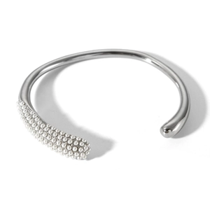 Detail view of silver open bracelet featuring white pearl clusters in an asymmetric design