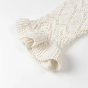 Detailed macro view of white pointelle knit fabric texture and delicate scalloped edges