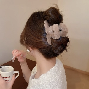 Close-up of a plush light brown cross hair claw clip showing soft furry texture
