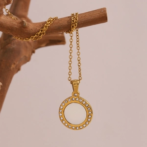Macro detail of 18K gold plated shell pendant with sparkling zircons on a branch