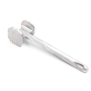Detailed close-up of dual-sided silver meat tenderizer with textured and flat heads
