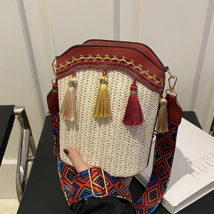 Bohemian straw bucket bag with red leather trim and colorful geometric strap
