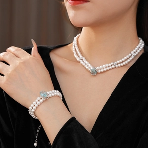 Détail de parure de perles à double rangée avec pierre précieuse ovale bleu clair