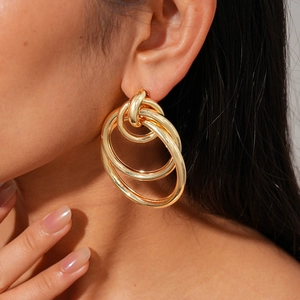 Close-up of golden geometric multi-layer intertwined circular hoop earrings for women