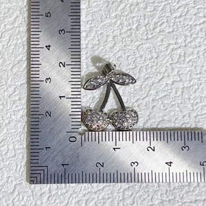 Silver cherry pendant with zircon and pearl, size measurement shown on a steel ruler