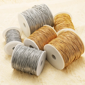Detailed macro view of gold and silver plated stainless steel snake chains on white spools