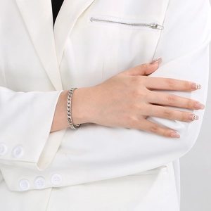 Sleek silver stainless steel curb chain bracelet styled on wrist with a white blazer