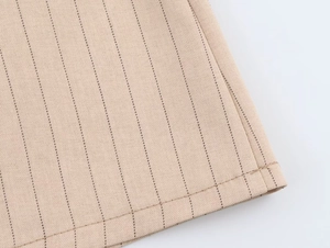 Gros plan sur le tissu à rayures kaki montrant le détail de la couture de l'ourlet