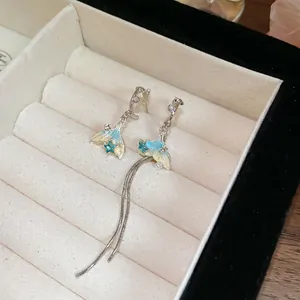 Asymmetric fishtail tassel earrings with blue enamel star and white pearls