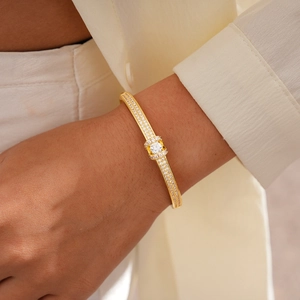 Detailed view of 18K gold plated oval bangle with pavé diamonds on model's wrist