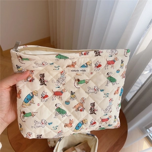 Close-up of quilted cotton cosmetic bag with cute dog prints and metal zipper detail
