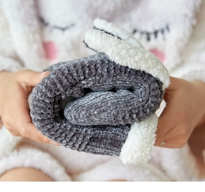 Close-up of soft grey and white fleece floor socks being held for warmth and comfort