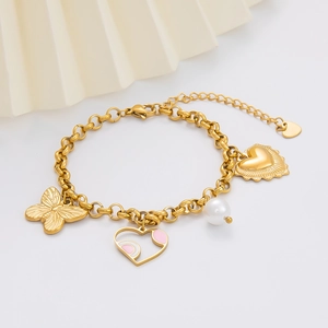 Macro view of gold stainless steel bracelet with butterfly, heart pendants and white pearl