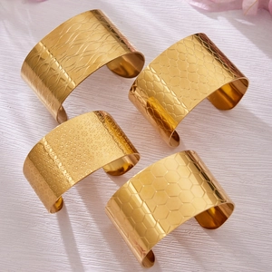 Bracelets larges dorés ouverts en quatre motifs texturés dont vagues et alvéoles