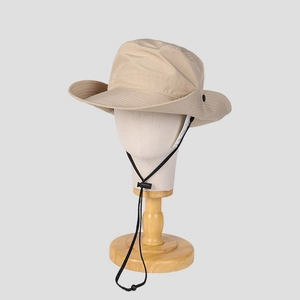 Detail of beige outdoor sun hat with wide brim and adjustable black chin strap