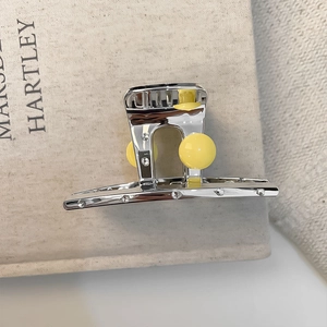 Silver metal hair claw clip with yellow spherical accents and sparkling crystals