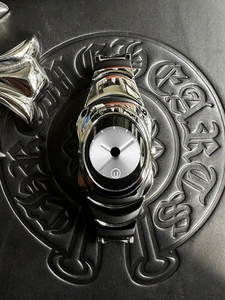 Macro shot of silver gothic style quartz watch with embossed cross patterns and date display