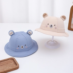 Detail view of baby sun hats featuring cute bear ears and embroidery in blue and beige