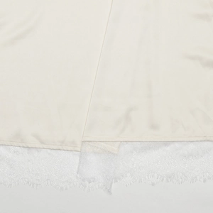 Détail de la soie abricot avec une bordure en dentelle blanche délicate au bas