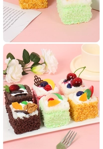 Macro shot of realistic artificial mousse cake slices with strawberry and chocolate toppings
