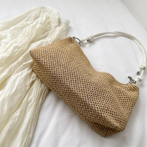 Handwoven straw tote bag in light brown with white rope straps for beach vacation