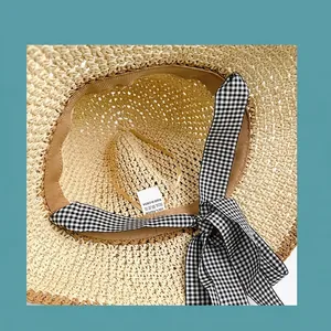Breathable wide brim straw hat with checkered bow ribbon and internal sweatband detail