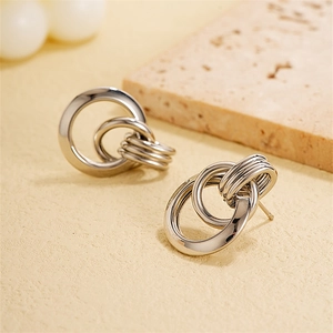 Macro detail of silver intersecting metal ring earrings with a polished mirror finish