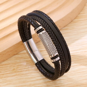 Close-up of black braided leather layers and silver magnetic clasp on men's bracelet