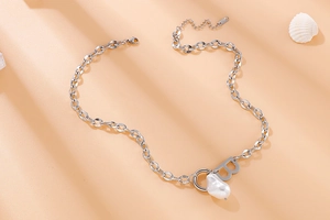 Close-up of silver chain necklace with letter B pendant and white baroque pearl