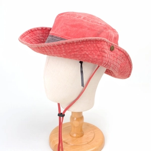 Detail view of red washed sun hat featuring a metal buckle and adjustable wind cord