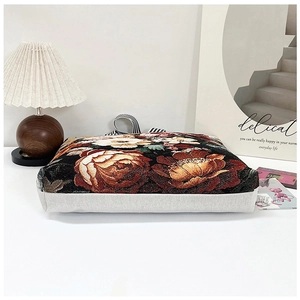 Detail view of ethnic 3D floral embroidery on canvas tote bag in cozy home setting