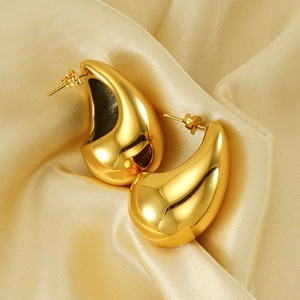 Elegant gold teardrop earrings in high-polished titanium steel on golden silk fabric