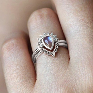 Detail of bohemian crown ring with teardrop moonstone and pavé setting on finger