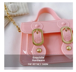 Close-up of pink jelly bag showing glossy texture, golden buckles, and metal chain strap