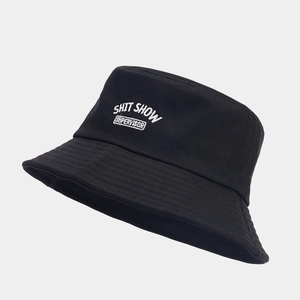 Black cotton bucket hat with white SHIT SHOW embroidered text in a casual style