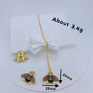 Macro view of gold bee pendant set with colorful pavé stones and 25mm size details