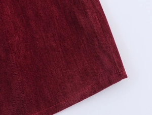 Detail shot of deep red chenille dress fabric featuring elegant texture and neat stitching
