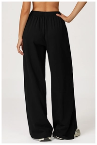 Rear view of high waist black wide leg sweatpants showing draped fabric and elastic waist