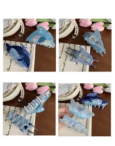 Detalle de pinzas de pelo de delfín azul con textura nacarada y resorte metálico fuerte