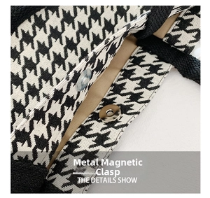 Detail of silver magnetic closure on a houndstooth woven tote bag with fabric texture