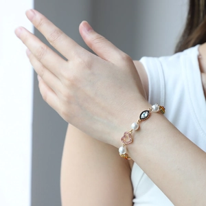 Vintage gold-tone charm bracelet with pearls, pink heart zircon and devil eye charm