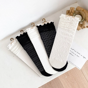 Lace mesh ankle socks for women featuring ruffle trim in classic black and white colors