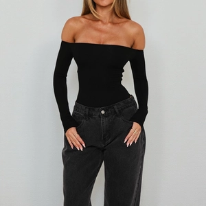 Detail of black off-shoulder long sleeve bodysuit featuring an open back and tight fit