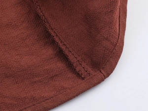 Close-up of the V-neck knot detail and soft reddish-brown suede fabric stitching