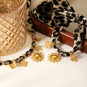 Close-up of leopard print ribbon necklaces with gold sun and cross pendants set