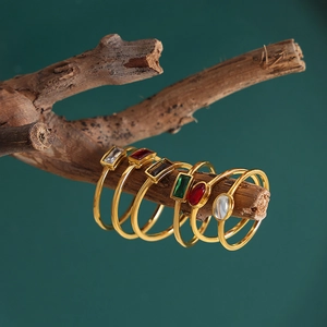 Vintage gold titanium steel rings with colorful oval gemstones on a natural branch