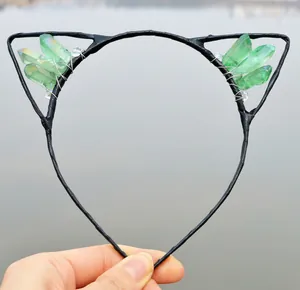 Detail view of handmade cat ear headband with green raw crystals and black metal frame